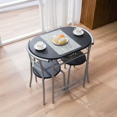 a table with two chairs and plates on it in the middle of a living room