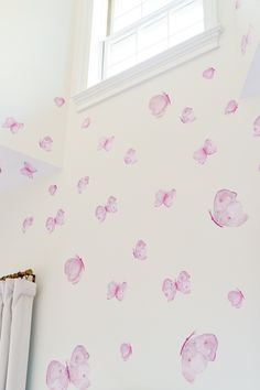 the wall is decorated with pink butterflies on it