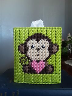 a green bag with a monkey on it and a tissue paper dispenser