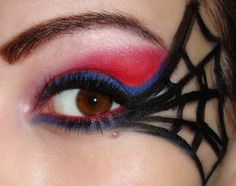 a woman's eye with spider web on the lashes and red eyeshadow