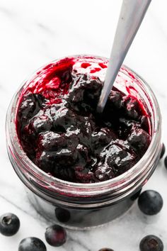 blueberries in a glass jar with a spoon