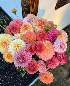 a vase filled with lots of pink and yellow flowers