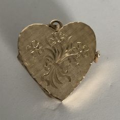 This hand-made heart locket is as sentimental and unique as it gets. It is made of 14 karat gold. It is both beautiful and functional. The bouquet, tied with a bow, details are breathtaking and the lattice satin background flickers in the light. Most lockets can hold 2 pictures but this one can hold 4 special photos close to your, or your loved one's heart! The photos are easy to slip through slots at top of locket. It is hard to match the workmanship of this locket and it's engraving. It was cr Victorian Yellow Gold Jewelry For Valentine's Day, Victorian Hallmark Jewelry For Wedding, Vintage Gold Jewelry For Wedding Gift, Victorian Wedding Jewelry With Hallmark, Vintage Self-winding Jewelry As Gift, Vintage Self-winding Jewelry Gift, Victorian Heart Charm Jewelry For Formal Occasions, Satin Background, Heart Locket