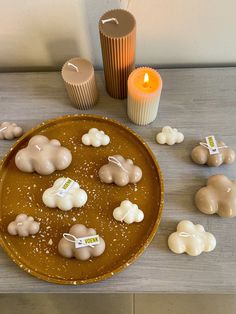 a plate with marshmallows on it next to candles and a candle holder