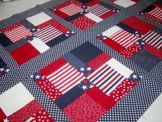 a red, white and blue patchwork quilt with american flag squares on it's sides