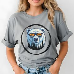 Get into the holiday spirit with our unique Christmas T-shirt featuring a cool bear rocking sunglasses. Look closely, and you'll see Merry Christmas and pine trees reflected in the shades. Perfect for cozy winter wear or as a fun holiday gift! 🎁If you are purchasing this as a gift, please include a written gift message for your recipient so they know who their gift is from🎁 Unisex, comfort colors. Looks great on everyone! T-shirt is pre-shrunk fabric and made with 100% ring-spun US cotton for Trendy Crew Neck T-shirt With Bear Print, Casual Cotton T-shirt With Bear Design, Casual White T-shirt With Bear Design, Casual Bear Design Short Sleeve T-shirt, Casual Bear Design Crew Neck Top, Casual Bear Print T-shirt For Streetwear, Casual Short Sleeve Tops With Bear Design, Trendy Short Sleeve T-shirt With Bear Print, Cool Christmas