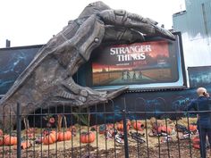 a man standing in front of a large sign with an image of a giant creature on it