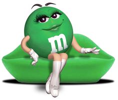 a green pillow with the letter m on it and a woman sitting on top of it