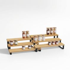 three wooden shelves with jars and spices on them