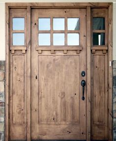 a large wooden door with windows on the side