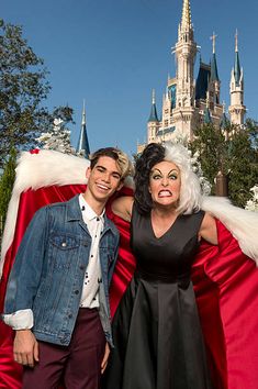 a man standing next to a woman in front of a castle