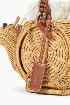 A hand-woven, snail-shaped wicker basket for any Summer occasion. The Escargot Bag features a leather handle with leather-wrapped detail and removable linen drawstring pouch to keep your essentials secure. Self: 100% Natural Wicker, Trim: 100% Cow Leather 9.75" W x 6" H x 5.25" D x 3.3" Drop Drawstring closure Brown Straw Bag With Round Handle For Travel, Straw Bucket Bag With Leather Round Handles, Leather Straw Bag With Rolled Handles For Vacation, Rattan Straw Bag With Leather Handles For Travel, Leather Straw Bag With Bamboo Double Handle, Straw Bag With Leather Handles And Round Handle, Leather Straw Bag With Round Handle, Brown Straw Bag With Woven Leather And Round Handle, Brown Leather Straw Bag With Rolled Handles