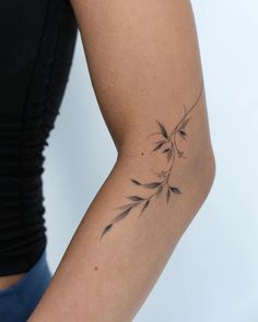 a woman's arm with a small tattoo design on the back of her left arm