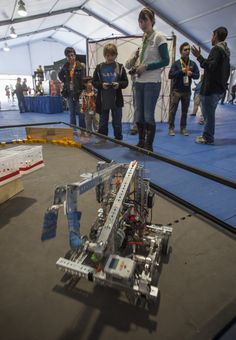 a group of people standing around a robot