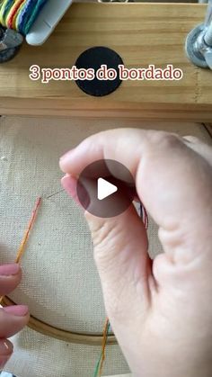 a person is working on something with yarn and needles in front of a sewing machine