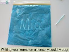 a blue bag with writing on it sitting next to a toothbrush and an eraser