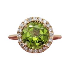 This beautiful ring features a 2.7ct sparkling round peridot in a stunning setting made in solid 14k gold with a halo of all natural earth mined diamonds. Enjoy the gorgeous shade of green and beautiful clarity of this natural peridot! This ring could make a gorgeous August birthstone gift! Specifications Item Type: Ring Center Stone: Peridot Treatment: None Weight: 2.7ct Head size: 9mm Shape: Round Hardness: 6.5-7 Metal: 14k/2.41g Diamond Clarity/Color: SI / G-H Diamond Count/Weight: 20/0.24 ct August Birthstone, Peridot Ring, August Birth Stone, Natural Earth, Beautiful Ring, Diamond Clarity, Cocktail Rings, Shades Of Green, Beautiful Rings