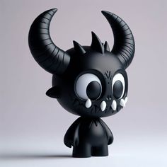 a black toy with horns on it's head is standing in front of a gray background