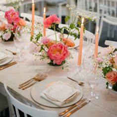 the table is set with flowers and candles