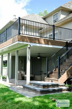 a house with a deck and stairs leading up to the front door