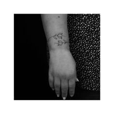 a woman's hand with a small tattoo on the left side of her arm