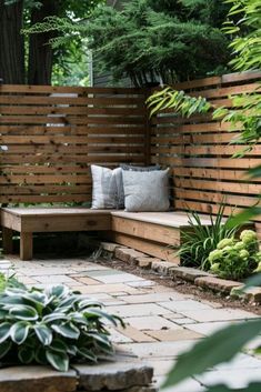 a wooden bench sitting next to a lush green forest