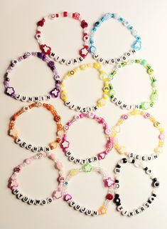 six bracelets with words written in different colors and sizes, all arranged on top of each other