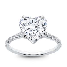 a heart shaped diamond engagement ring with pave set diamonds on the band and shoulders