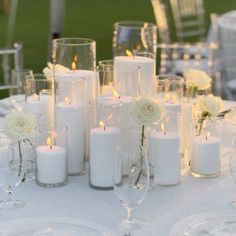 a table topped with lots of white candles