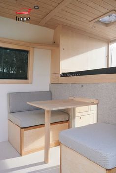 the inside of a camper with two benches and a table