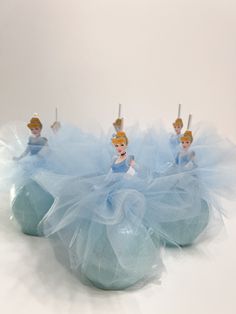 there are some little princess figurines sitting on top of each other in blue tulle