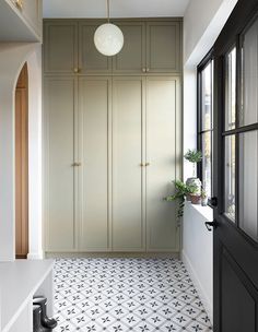 an empty room with white and black flooring next to a large cabinet in the corner