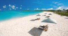 beach chairs and umbrellas are lined up on the white sand at an empty beach