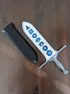 a white and blue object sitting on top of a wooden table next to a knife