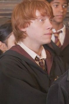 two young men in harry potter robes standing next to each other and looking off into the distance