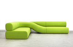 a lime green couch sitting on top of a white tile floor next to a wall