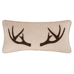 a white and brown striped pillow with antlers on it