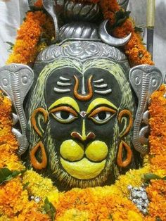 an elaborate mask is surrounded by flowers