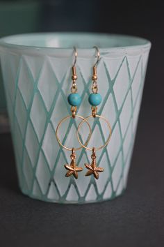 Lovely earrings with natural turquoise stone 6 mm beads, gold tone hoops, seafish charms and gold tone earring hooks. Earring hooks are from nickel free and lead free metal. Perfect for everyday wear! *The total lenght of earrings is about 59 mm including the earring hooks. Other earrings of my shop you can see here: https://www.etsy.com/shop/NaTavelli?section_id=13757927 Thanks for visit. Gold Earrings For Beach, Gold Dangle Earrings For Beach, Ocean-inspired Gold Jewelry With Ear Wire, Gold Pierced Hoop Earrings For Beach, Gold Metal Hoop Earrings For Beach, Ocean-inspired Gold Wire Wrapped Jewelry, Gold Jewelry With Starfish Charm, Gold Earrings With Starfish Charm For Beach, Gold Metal Jewelry With Starfish Charm