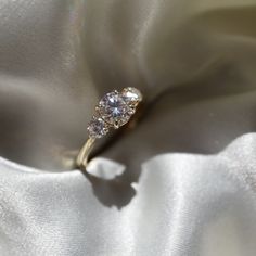 an engagement ring sitting on top of a white cloth