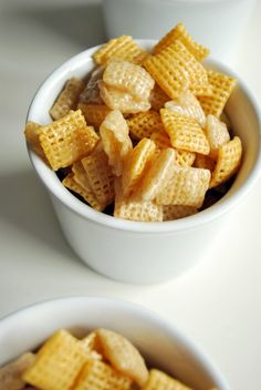 two white bowls filled with cheetos sitting on top of a table next to each other