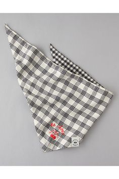 a black and white checkered bandana on a gray background with red flowers in the corner