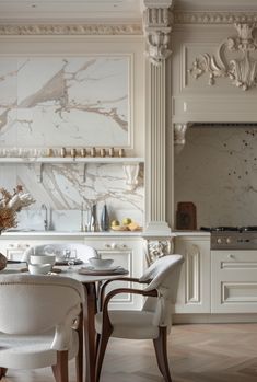 an elegant dining room with marble walls and flooring is pictured in this image, there are two white chairs at the table