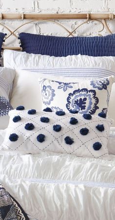 a bed with blue and white pillows on it