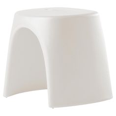 a white plastic stool that is sitting on the ground