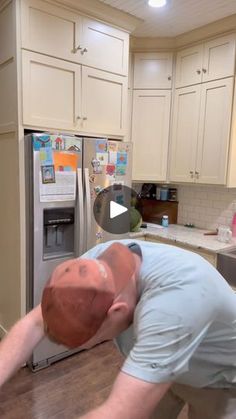 a man bending over to pick something out of the refrigerator