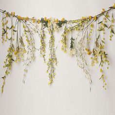 yellow and white flowers are hanging from a string