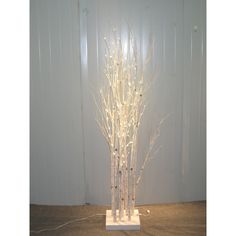 there is a white tree with no leaves in the light up display on the floor