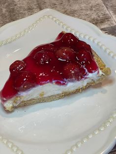 a piece of cheesecake with cherries on top is sitting on a white plate