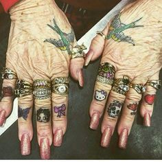 two hands with tattoos and rings on them